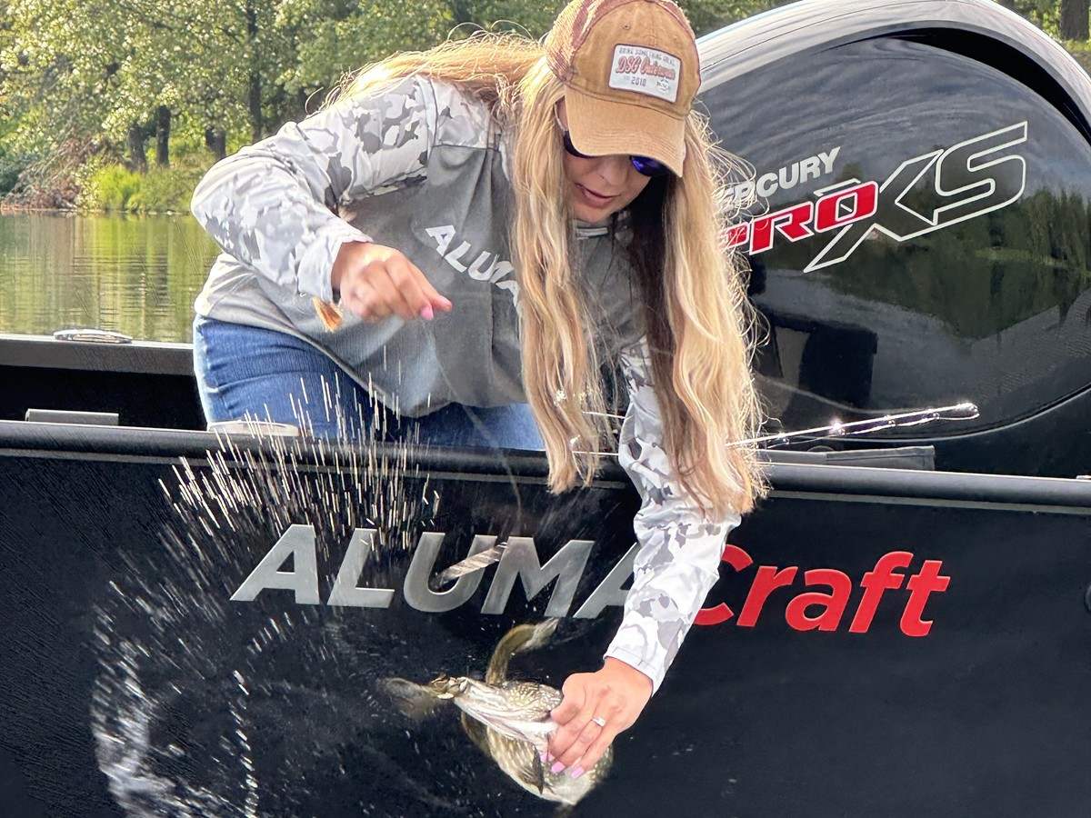 Krysten Potega, pulling a fish out of the water aboard her Alumacraft fishing boat
